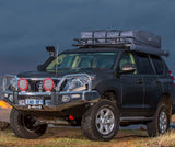 An ARB Touring Roof Racks For Toyota 4Runner 4th Gen/ LandCruiser Prado 150 Series ARB 3813200 is parked on a dirt road with superior mandrel bending.