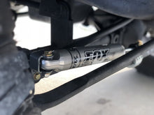 Load image into Gallery viewer, A close-up of a vehicle&#39;s suspension, showcasing the FOX 2 inch Jeep Wrangler JK 07-18 2Door Lift Kit (Medium Load) for enhanced ride quality, by Fox Racing.