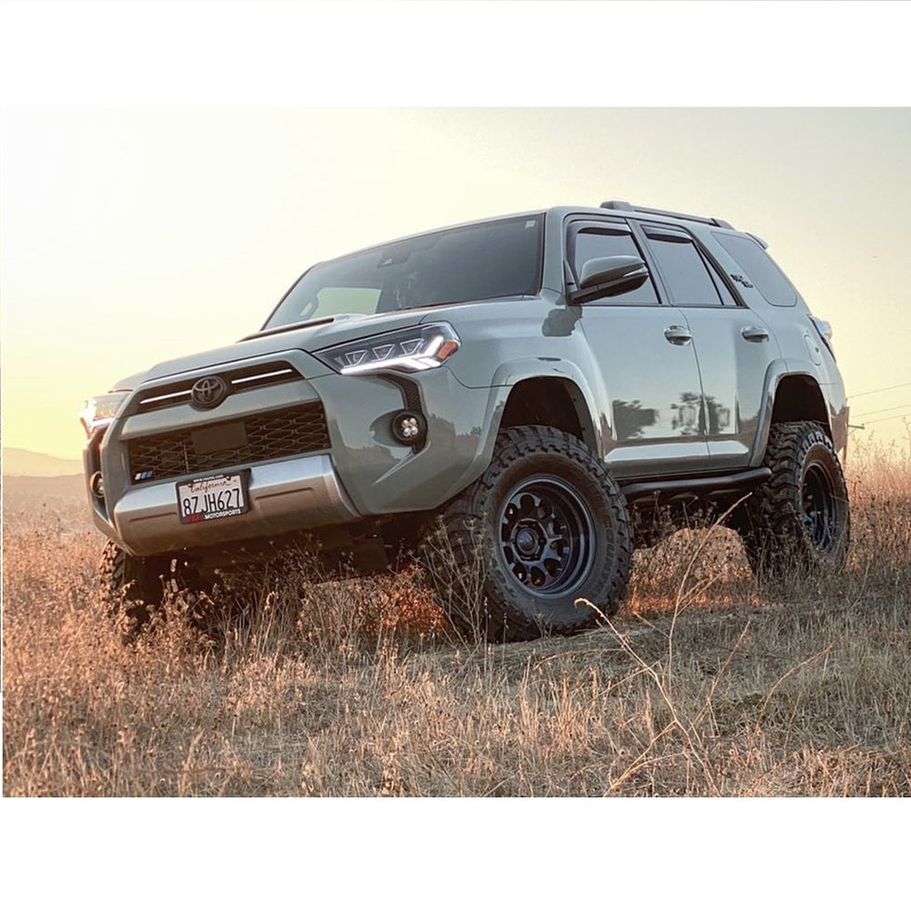 The 2019 Toyota 4Runner, equipped with the King Shocks KING 2 - 3 inch Lift Kit for 4Runner w/ KDSS (10-23) and impressive off-road performance capabilities, is parked in a field.