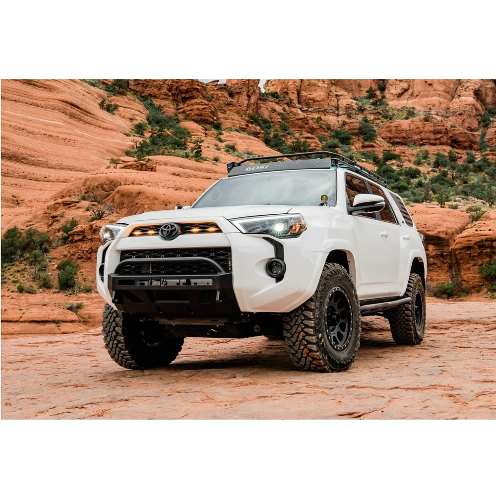 The white Toyota 4Runner, equipped with the KING 2 - 3 inch Lift Kit for 4Runner w/ KDSS (10-23) from King Shocks for enhanced off-road performance, is parked in the desert.