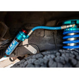 A blue King Shocks 0 - 2 inch Leveling Kit for Lexus GX470 (03-09) is attached to the underside of a vehicle, enhancing its off-road performance and suspension articulation.