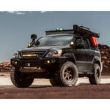A black SUV with King Shocks is parked in the desert, showcasing the KING 2 - 3 inch Lift Kit for Lexus GX470 (03-09)'s off-road performance and advanced valving technology.