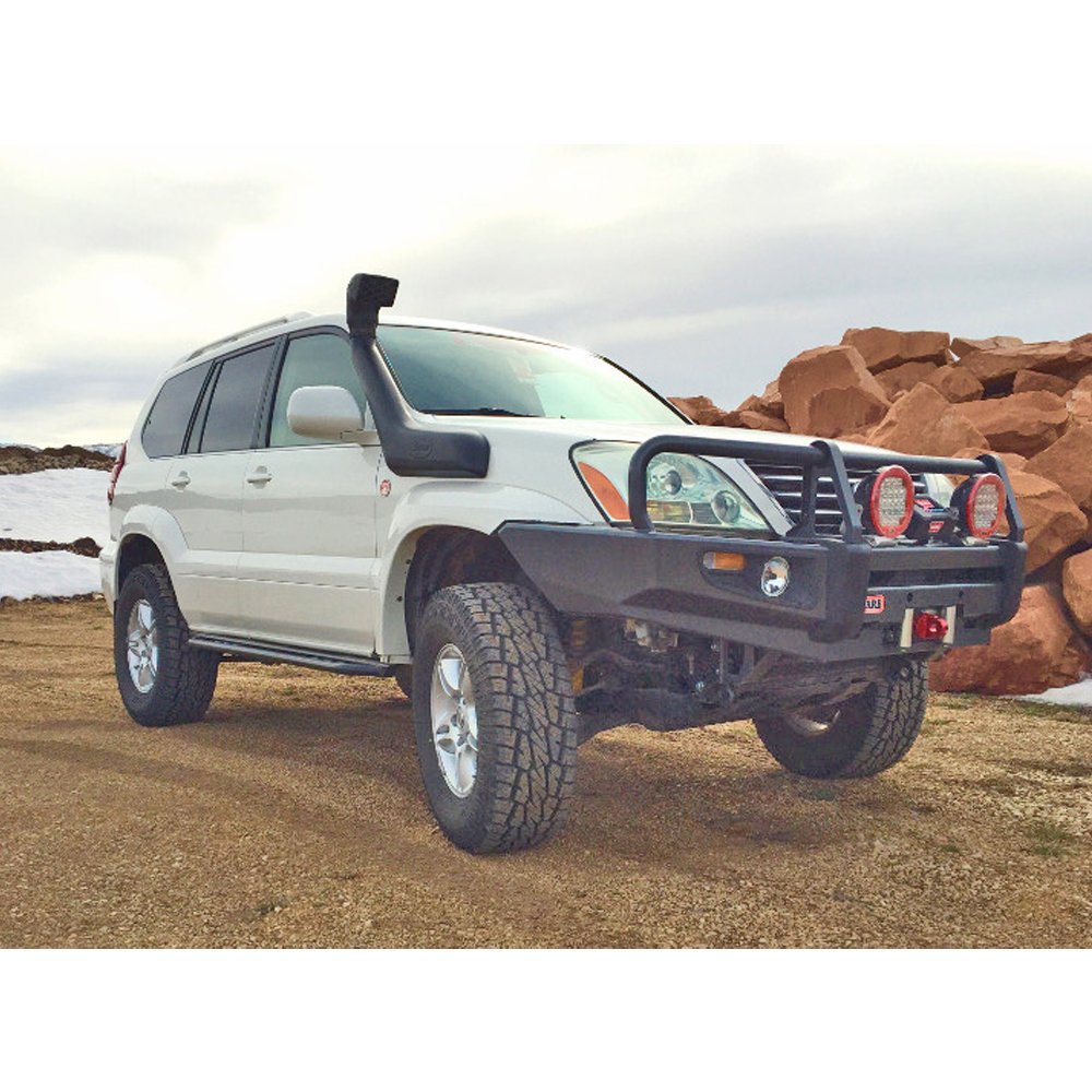 A white Toyota Land Cruiser with advanced valving technology parked on a dirt road.