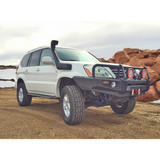 A white Toyota Land Cruiser with advanced valving technology parked on a dirt road.