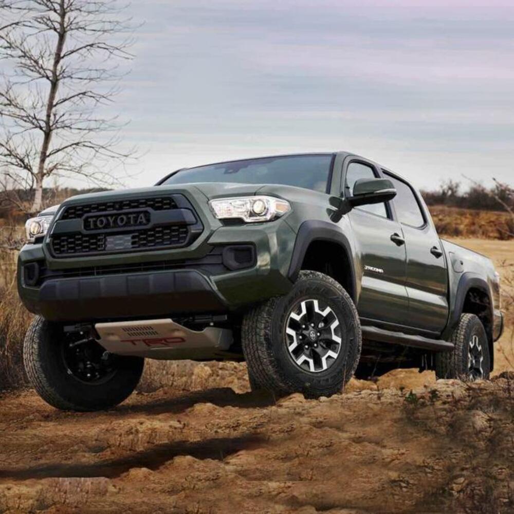 The 2019 Toyota Tacoma with enhanced stability and Off-road performance is driving on a dirt road, equipped with the KING 2 - 3 inch Lift Kit for Tacoma (05-23) from King Shocks.
