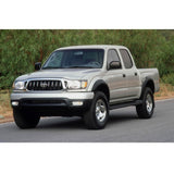 A silver Toyota Tacoma with exceptional off-road performance is parked on the side of the road equipped with King Shocks, including the KING 2 - 2.5 inch Lift Kit for Tacoma (98-04).