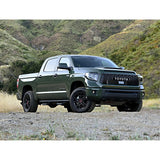 The 2019 Toyota Tundra, equipped with the KING 2 - 3 inch Lift Kit for Tundra (07-21) from King Shocks, is parked on a dirt road.