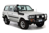 A white suv is parked on a Safari Snorkel Intake Kit Toyota Landcruiser 80 Series (1990-1997) ARB SS82R background.