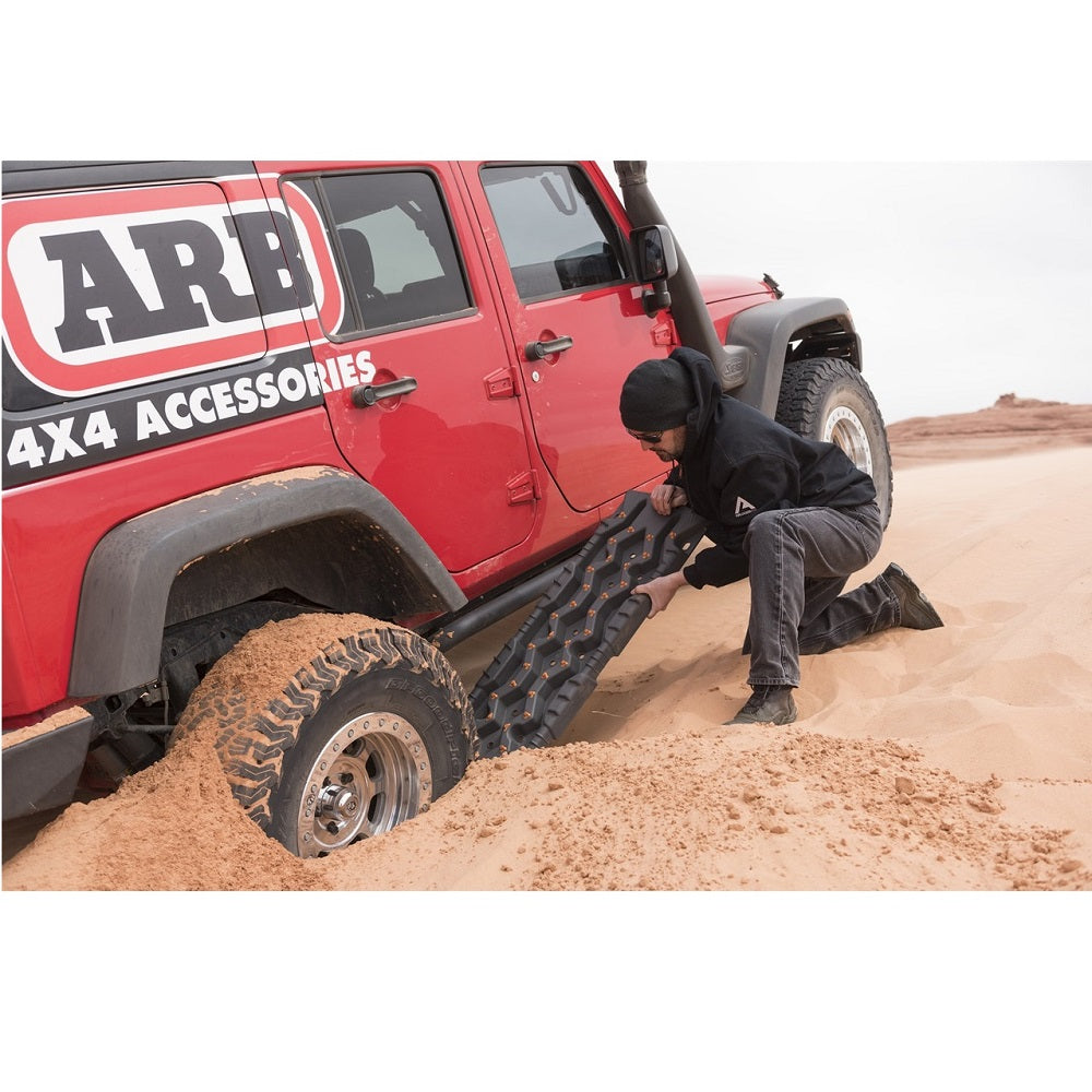 An ARB TRED Pro Recovery Boards TREDPROR - Red in the sand utilizing traction recovery equipment.