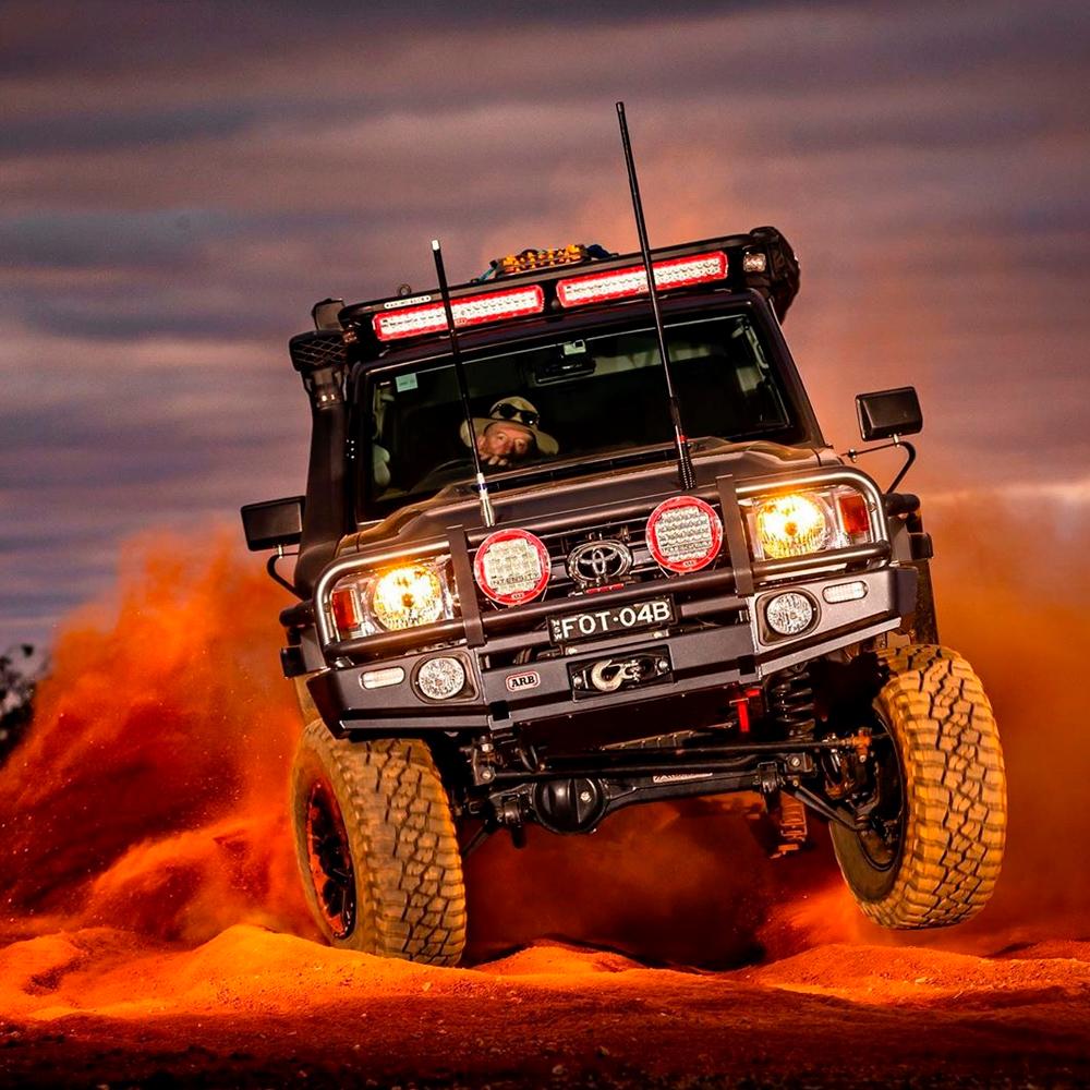 An Old Man Emu Toyota FJ Cruiser traversing the desert with an ARB Old Man Emu Rear Nitrocharger Sport 60081 for Prado 150 Series LWB (Coil Spring Models Only) and high-quality oil for optimal performance.