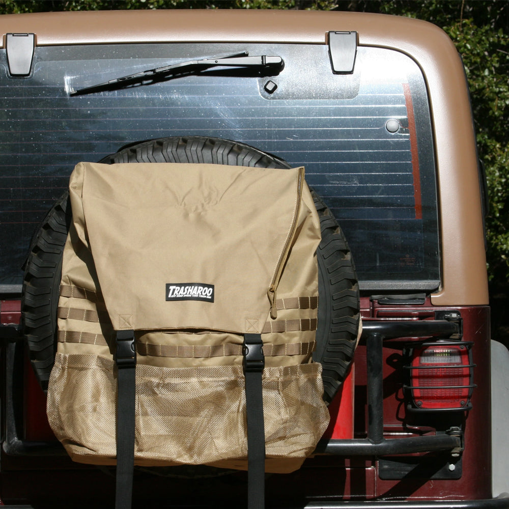 A jeep with a Trasharoo Spare Tire Trash Bag strapped to the back of it, made by the brand Trasharoo.