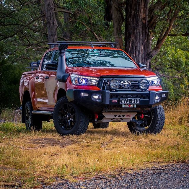 An Old Man Emu Toyota Hilux parked on a dirt road, showcasing its ride height increase achieved through easy installation of Old Man Emu Rear Coil Springs 2899 for Toyota Prado 150 Series (LWB MODELS) 1.5 inch Estimated Lift.