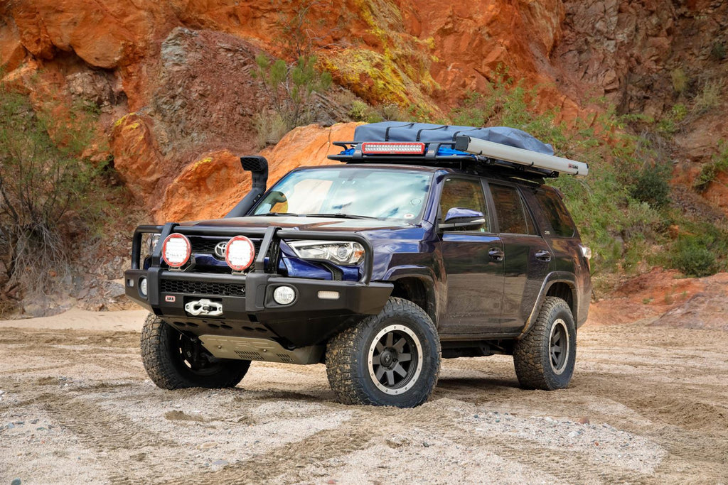 A Toyota 4Runner, with its vehicle-specific design and underbody protection from the ARB Under Vehicle Skid Plates System without kinetic (Non-KDSS) 5421100, is parked on a dirt road.