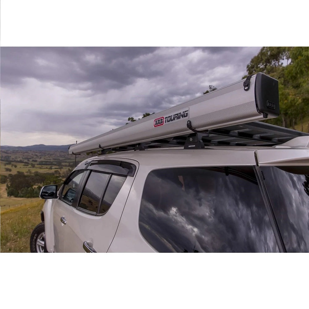 A waterproof ARB SUV with an aluminum ARB roof rack and ARB Touring Aluminum Awning with Light 814411.