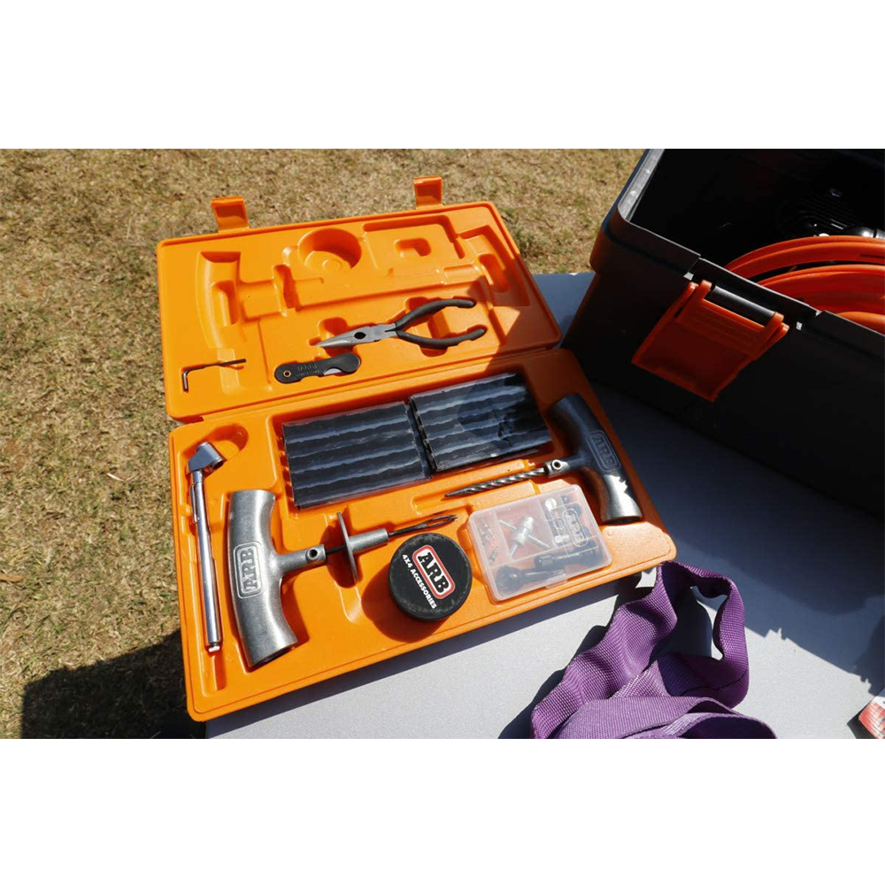 An ARB Speedy Seal Tire Repair Kit Series II 10000011 with an array of tools spread out on a table.