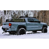 A Toyota Tacoma equipped with an Old Man Emu OME BP-51 2-3 inch Lift Kit for Tacoma (05-23) bravely maneuvers through the snowy terrain with its adjustable damping capabilities.