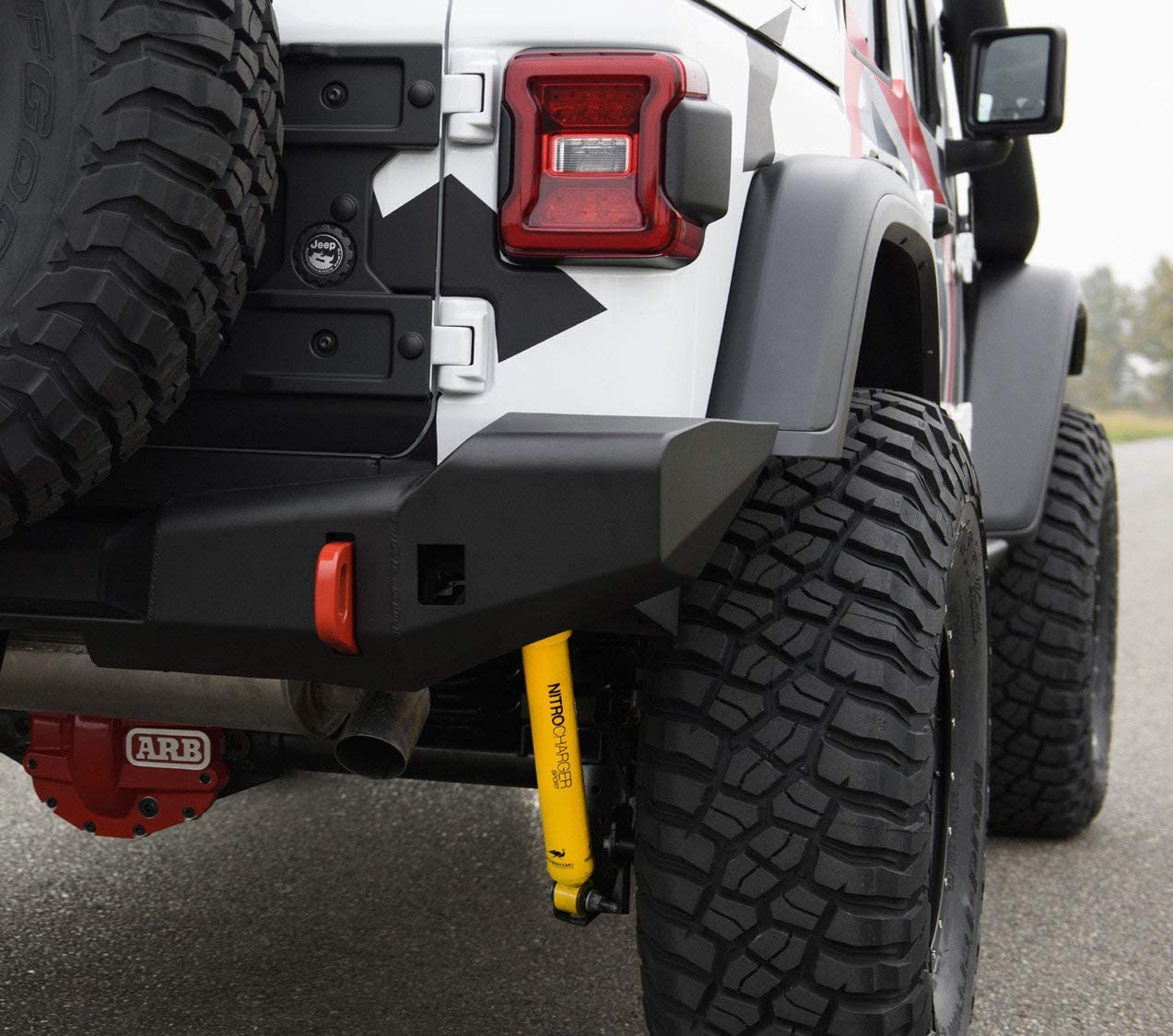 The rear bumper of a jeep wrangler, featuring the Old Man Emu Rear Nitrocharger Sport L Series 60071L for Toyota Landcruiser 80 & 105 Series.