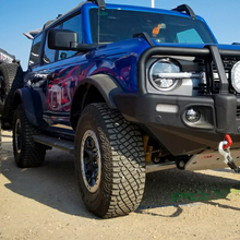 Load image into Gallery viewer, A blue Ford Bronco is parked in a dirt lot, showcasing its ride quality and showcasing the performance of the ARB Old Man Emu Front Stabilizer Bar Kit OMESTAB10 for Ford Bronco.