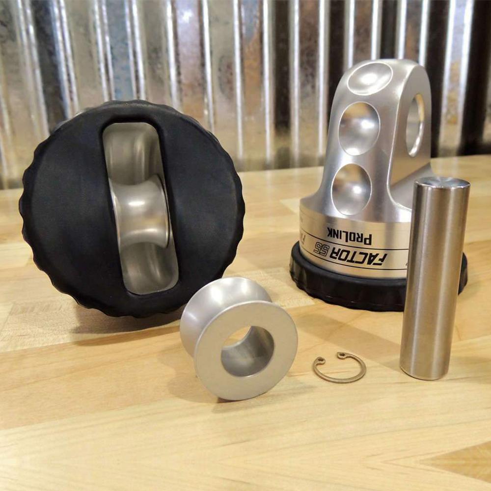 A set of Factor 55 Synthetic Rope Spool 00096 metal parts with load spool on a wooden table.