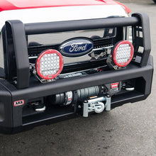 Load image into Gallery viewer, A red Ford F-250 pickup truck with a Sahara Style Modular Winch Bumper Kit ARB 2236020 by ARB, which has secure mounting points for an electric winch provision and a light bar on the front bumper.