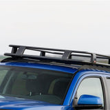 A blue SUV with a ARB Steel Roof Rack System for Jeep Wrangler 2018-2020 3813030KJL on top, perfect for cargo transportation.