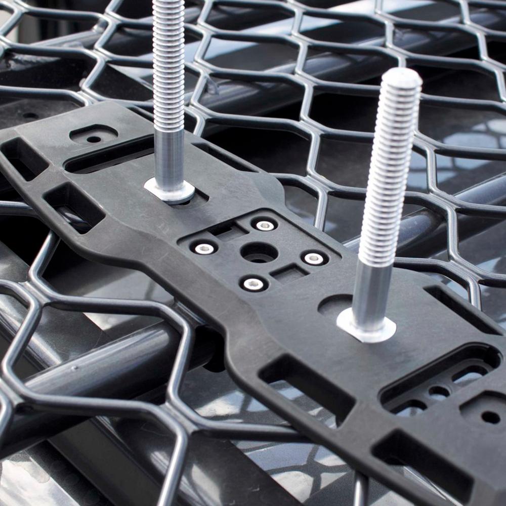 A close up of a metal rack with the ARB Mount Adapter TRED TPMKBA01 and bolts on it.