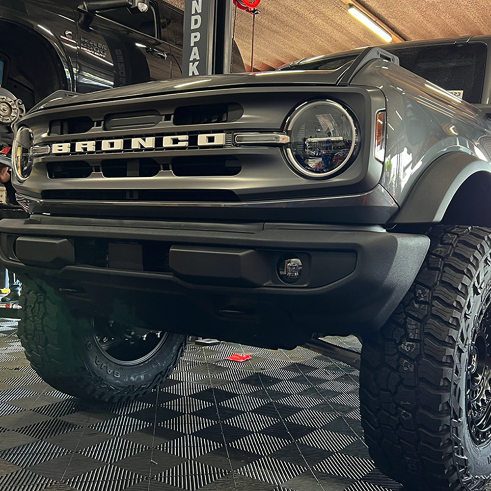 An ARB Old Man Emu Rear Coil Springs 3204 for Ford Bronco Base, Big Bend, Outer Banks, Wildtrack (2021-2022) by Old Man Emu is parked in a garage.