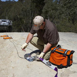 A man is working on a Snatch Pack Recovery Bag ARB502A from the brand ARB.
