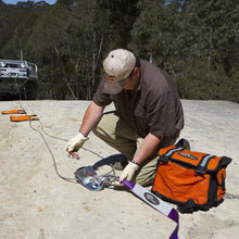 Load image into Gallery viewer, A man is working on a Snatch Pack Recovery Bag ARB502A from the brand ARB.