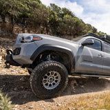 The 2019 Toyota Tacoma, equipped with the Fox Racing 2.0 Performance Series 2.0 Front Coil-Over IFP Shock 985-02-002 for Toyota Tacoma 4WD and RWD/ 4Runner / FJ Cruiser / Land Cruiser Prado 120 (Pair), is effortlessly conquering a rocky trail.