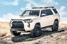 Load image into Gallery viewer, The 2019 Toyota 4Runner with an ARB bumper is parked on a dirt road, equipped with the ARB LED Fog Light Kit for Toyota 3500910 for off-roading.