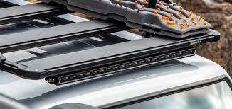The ARB Slimline Roof Rack Light 1780500 of a jeep is full of tools, with a reflector design for improved visibility.