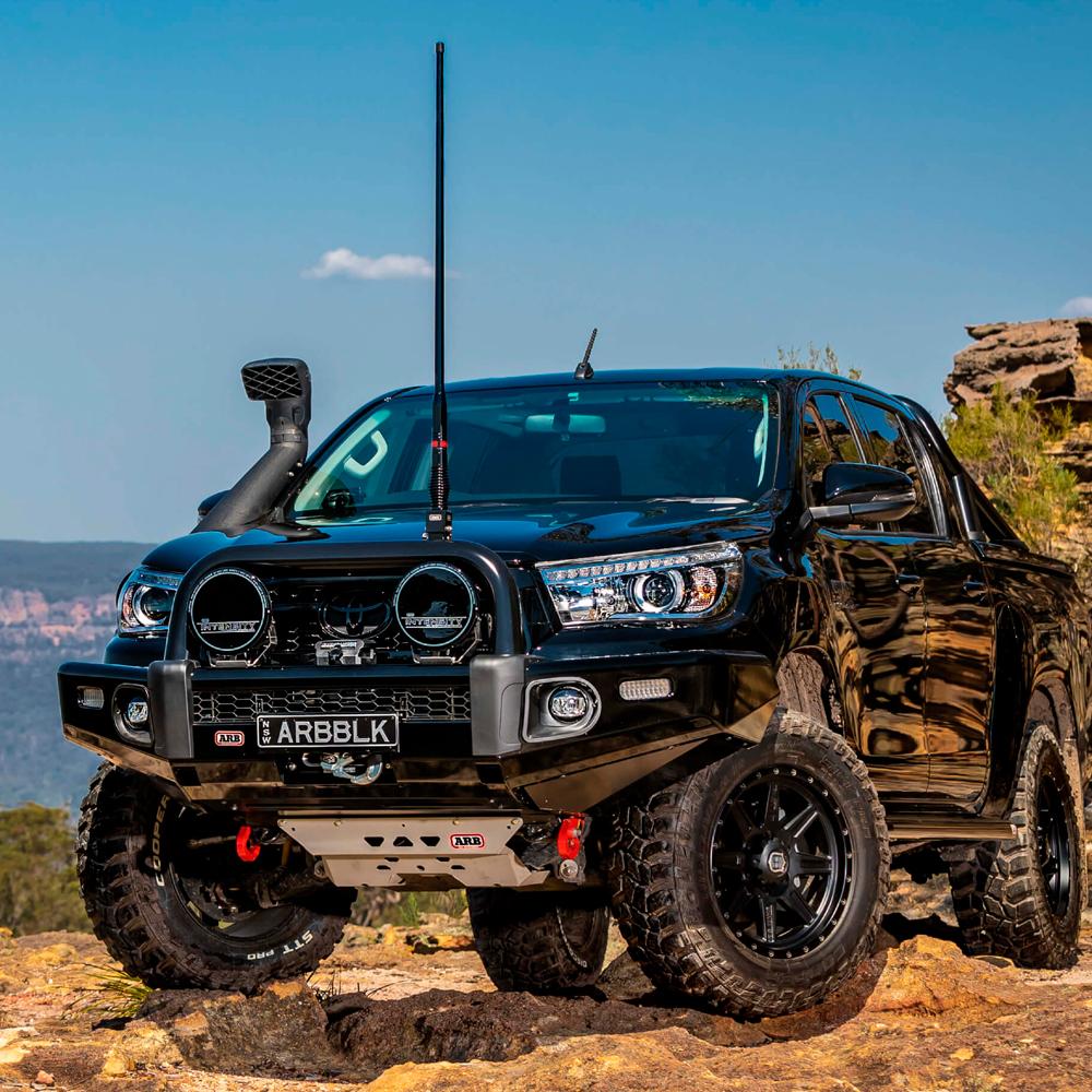 A black Toyota Tacoma, equipped with the ARB Old Man Emu Rear Nitrocharger Sport 60080 for Toyota 4Runner/FJ Cruiser / Prado 150 Series by Old Man Emu, is parked on a rocky hill.