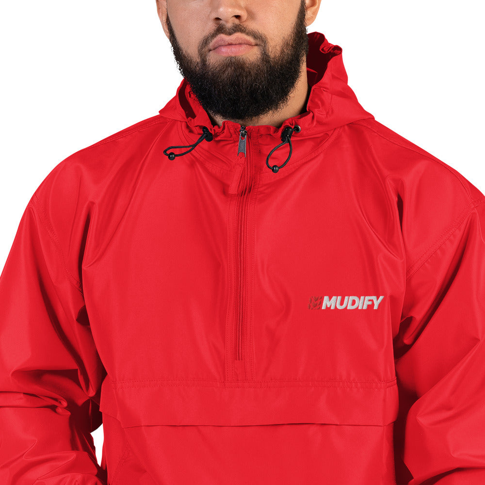 A man wearing a red Mudify packable jacket with the word muppy on it.