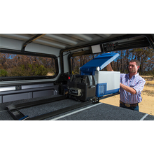 Load image into Gallery viewer, A man carefully installing the ARB Threaded Socket Surface Mount Outlet for ARB Fridge 10900028 in the back of a truck.