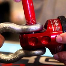 Load image into Gallery viewer, A person is holding a Factor 55 ProLink XXL Shackle Mount Assembly in Red 00210-01 made of 6000 series billet aluminum on a bike.