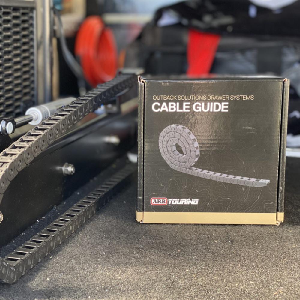 The ARB Cable Guide CABRUN, made of steel material, is sitting on top of a box.