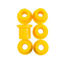 Six yellow Old Man Emu rubber bushings on a white background, providing durability.