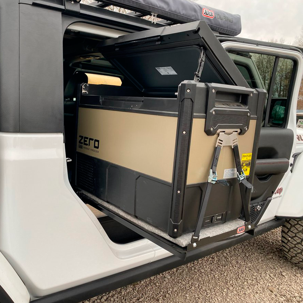 A durable ARB Jeep Wrangler with versatile capacity, featuring an ARB Zero 73 Quart Dual Zone Portable Fridge Freezer 10802692 in the back seat.