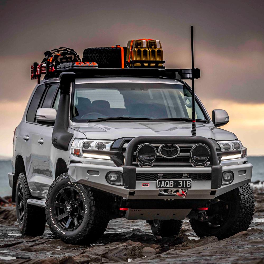 An Old Man Emu Toyota Land Cruiser, equipped with Old Man Emu Front Coil Springs 2888 for Toyota 4Runner, Prado 150 Series, Tacoma, Hilux for added suspension support, is parked on a rocky beach.