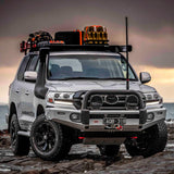 An Old Man Emu Toyota Land Cruiser, equipped with Old Man Emu Front Coil Springs 2888 for Toyota 4Runner, Prado 150 Series, Tacoma, Hilux for added suspension support, is parked on a rocky beach.