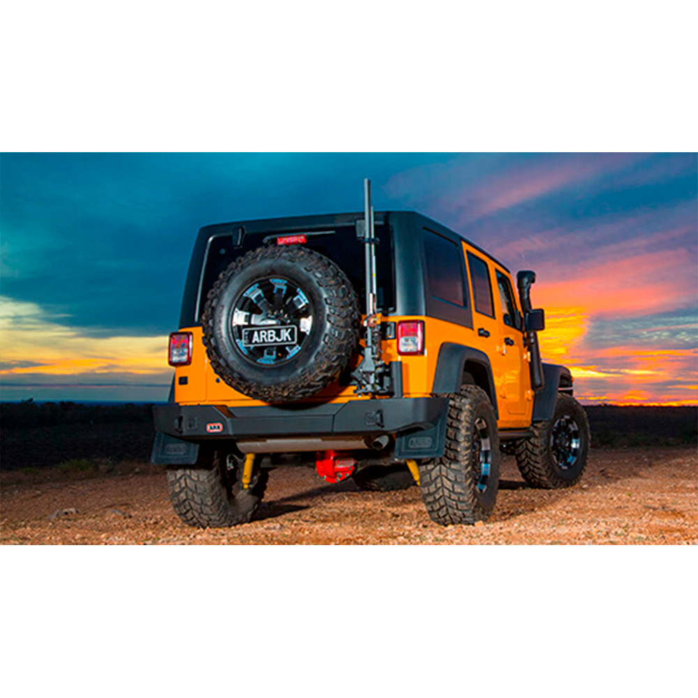 An Old Man Emu jeep wrangler parked on a dirt road at sunset, showcasing its ARB Old Man Emu Rear Nitrocharger Sport Shock 60067L and high-quality oil.