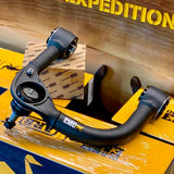 A box featuring a pair of ARB Old Man Emu Upper Control Arms UCA0005 for Toyota Tacoma (2005-2023), offering suspension lift and allowing for caster and camber adjustment.