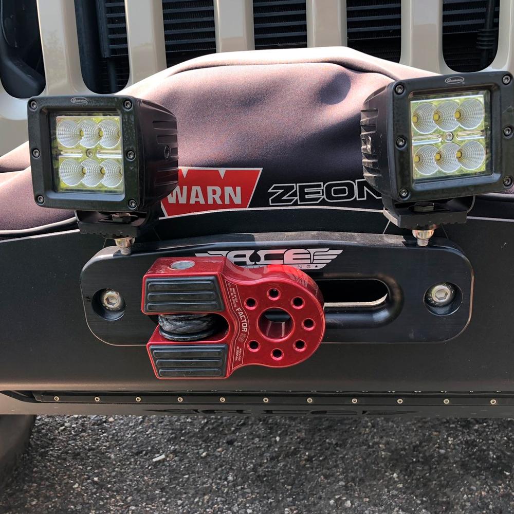 A jeep with two lights on the front bumper and a Factor 55 FlatLink Winch Shackle Mount 00050-01.