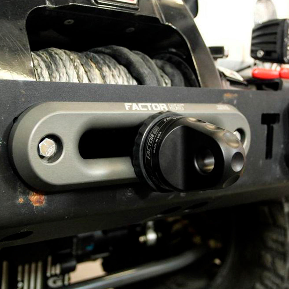 A close up of a black bumper on a jeep with Factor 55 Shackle Mount in Gray 00015-04 winch hooks.