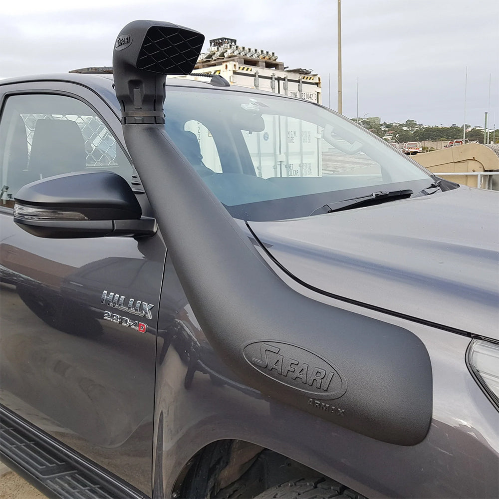A Turbo Diesel Toyota Hilux with a hood scoop and a Safari Snorkel Intake Kit SS123HP, perfectly suited for off-road adventures.