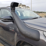 A Turbo Diesel Toyota Hilux with a hood scoop and a Safari Snorkel Intake Kit SS123HP, perfectly suited for off-road adventures.