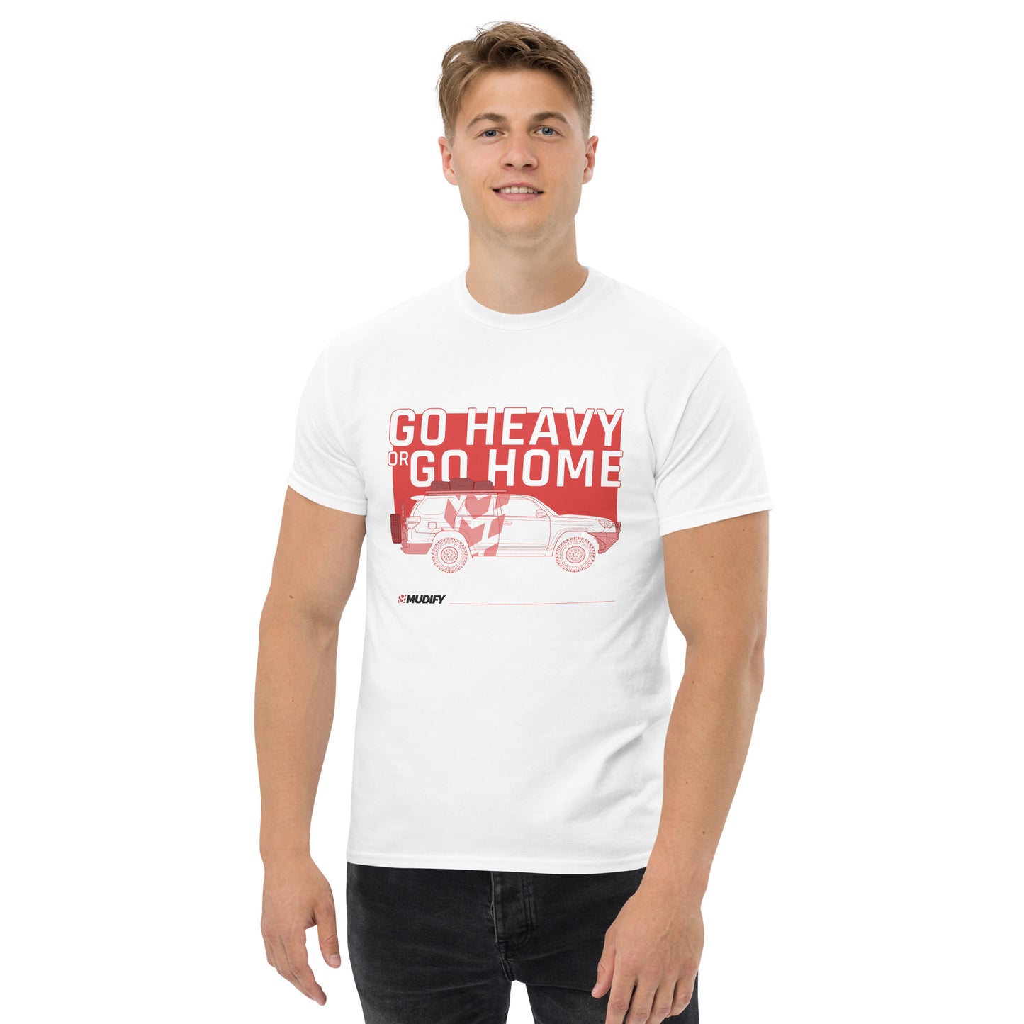 A trendy man is wearing a white t-shirt with a structured look that says "Go Heavy or Go Home" by Mudify.