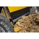 A yellow ARB Deluxe Rock Rails ARB 4420100 is parked next to a rocky area.